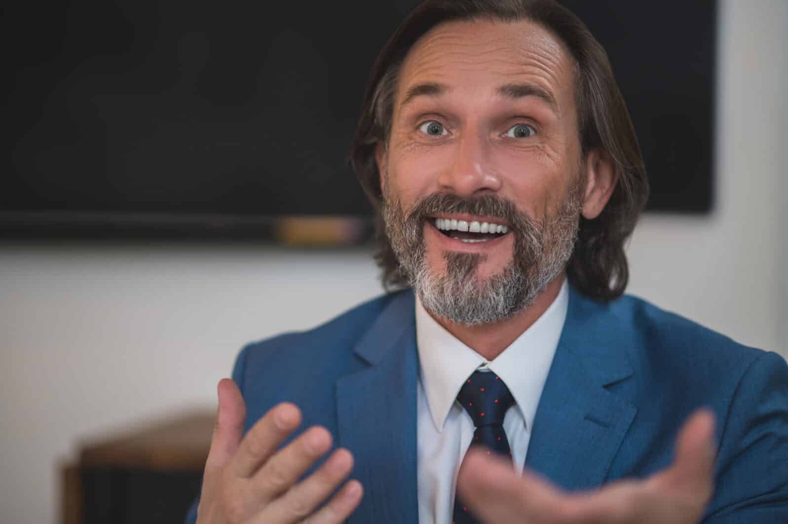 Bearded businessman in a suit looking surprised