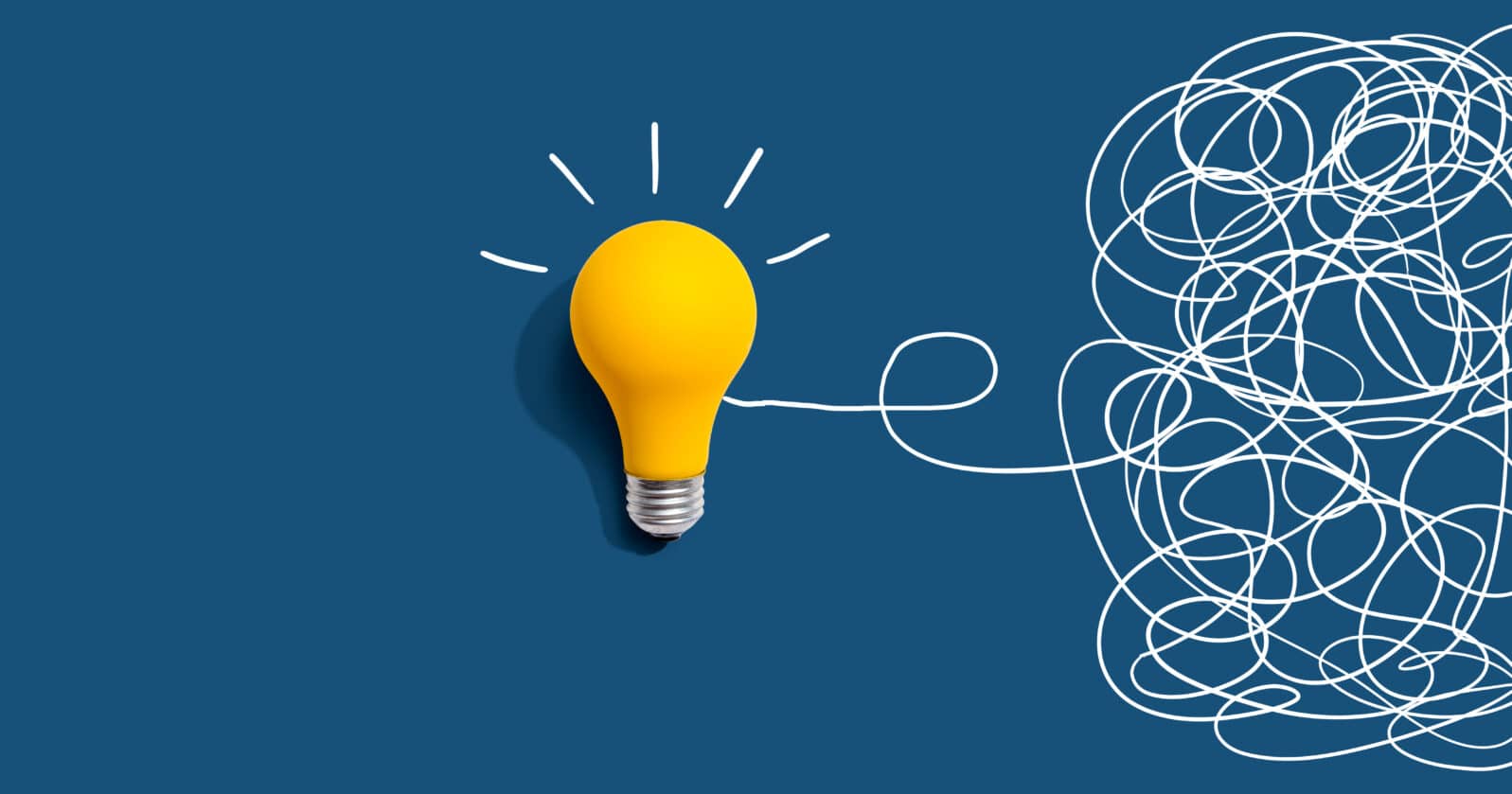 Clarifying complex ideas theme with light bulb - Flat lay