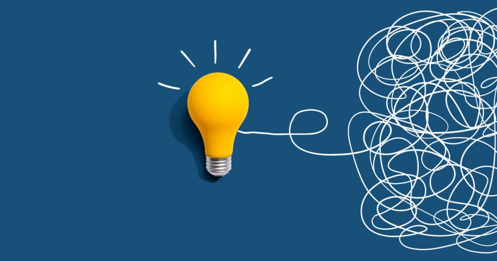 Clarifying complex ideas theme with light bulb - Flat lay