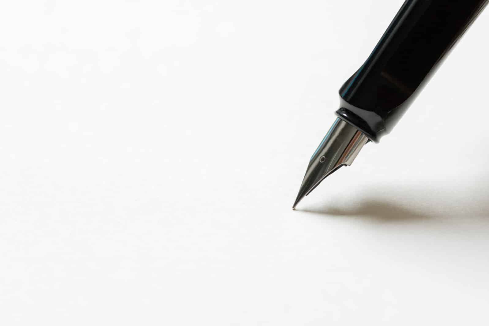 Fountain pen placed on the white paper opaque. Communication to business transactions, education, work, suitable as a background image.