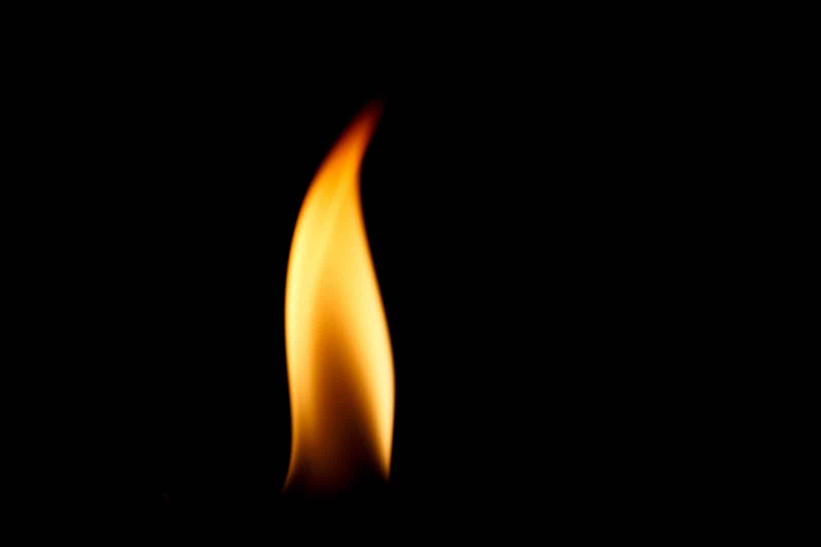 Single naked flame in black space.